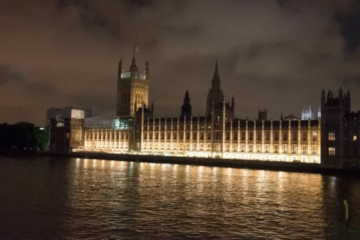 Il Parlamento di Westminster illuminato di notte, riflesso sul Tamigi