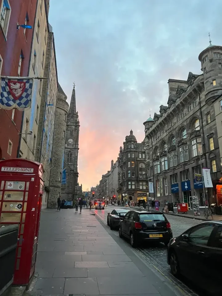 Via di Edimburgo al tramonto, con una cabina telefonica rossa e palazzi in pietra
